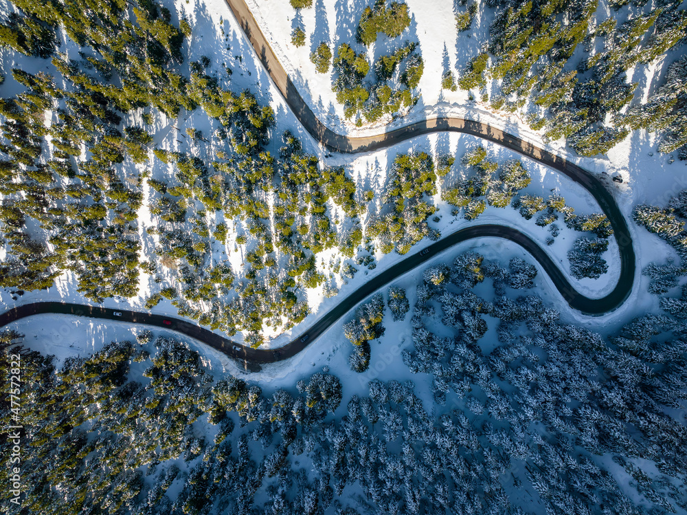 Aerial top down view of a winter landscape with snow covered fir trees and street slopes at Parnassus mountain, Greece