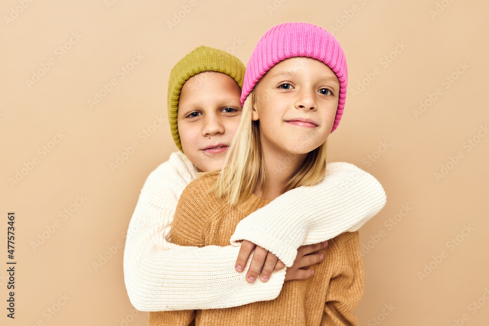 children together in multi-colored hats fun casual wear beige background children together in multi-colored hats fun casual wear beige background