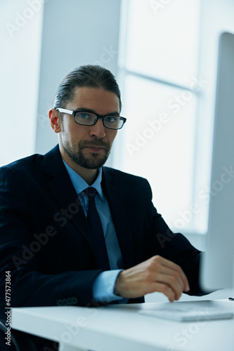 business man in a suit with glasses in the office at his desk