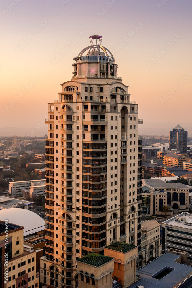 Obraz premium A vertical sot of the Michelangelo towers in Sandton, Johannesburg taken on a clear day during a golden sunset using a vertical composition. 