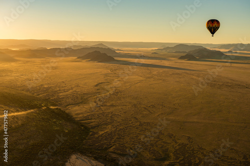 A horizontal shot of a hot air balloon flight over the Sossusvlei landscape at sunrise, Namibia