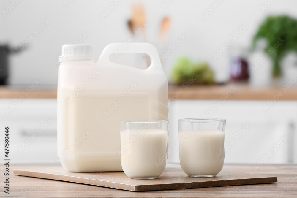 Gallon bottle and glasses of milk on table in kitchen