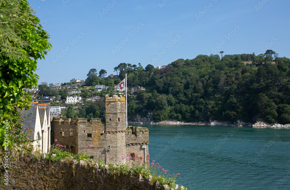 Dartmouth castle an old artillery fort, built to protect the harbour by the water with blue sky in the background