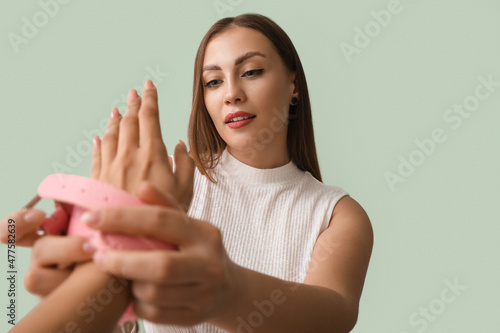 Young woman putting handcuf...