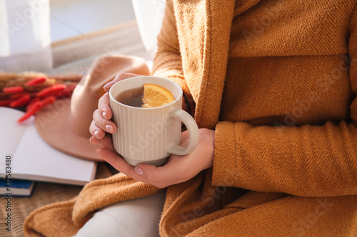 Woman holding cup of delicious tea, closeup