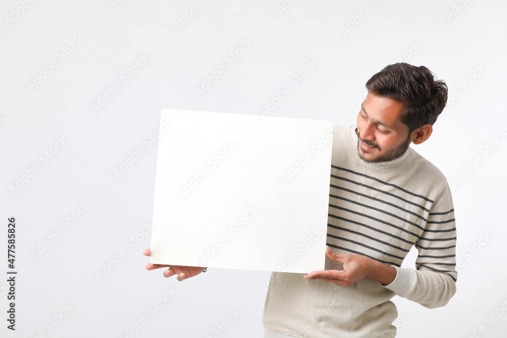 Young Indian college student showing blank signboard on white background. Young Indian college student showing blank signboard on white background.