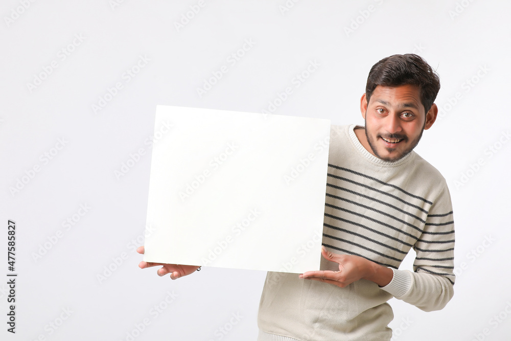 Young Indian college student showing blank signboard on white background. Young Indian college student showing blank signboard on white background.