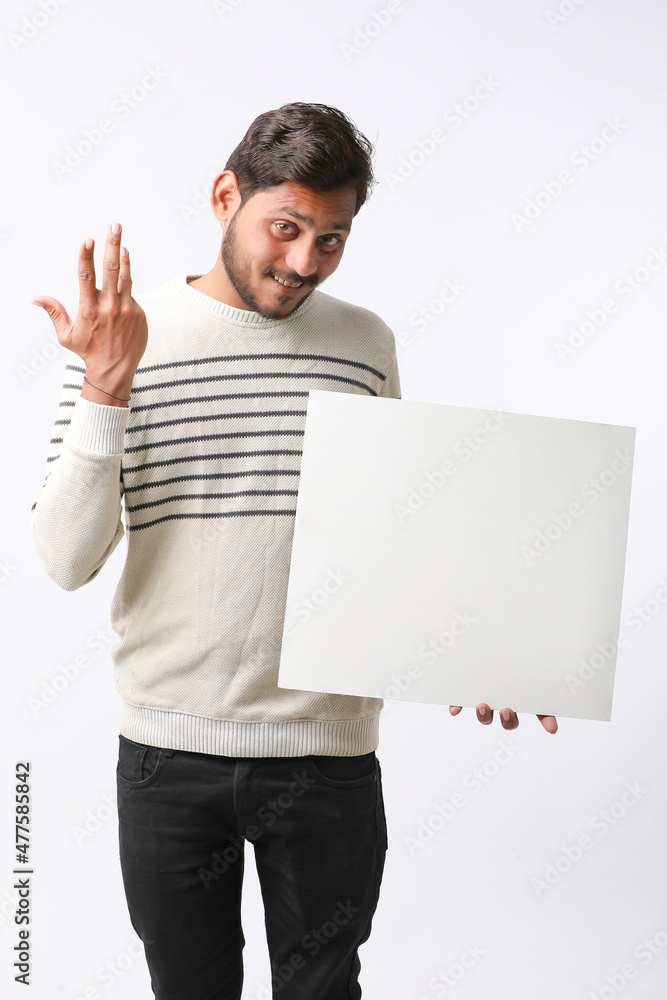 Young Indian college student showing blank signboard on white background. Young Indian college student showing blank signboard on white background.
