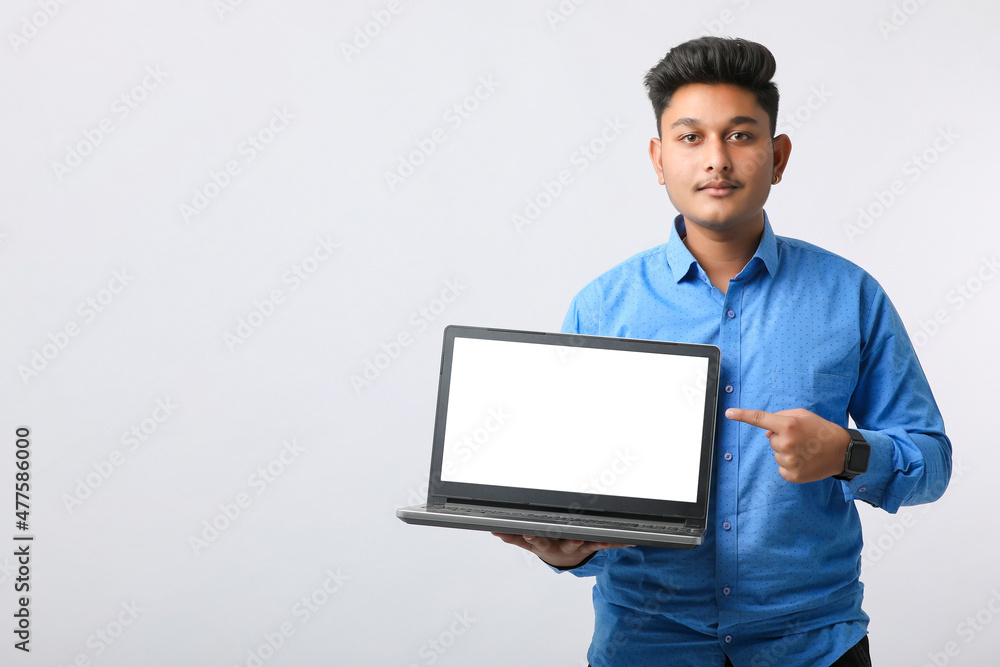 Young indian man showing laptop screen on white background. Young indian man showing laptop screen on white background.