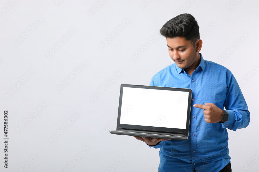 Young indian man showing laptop screen on white background. Young indian man showing laptop screen on white background.