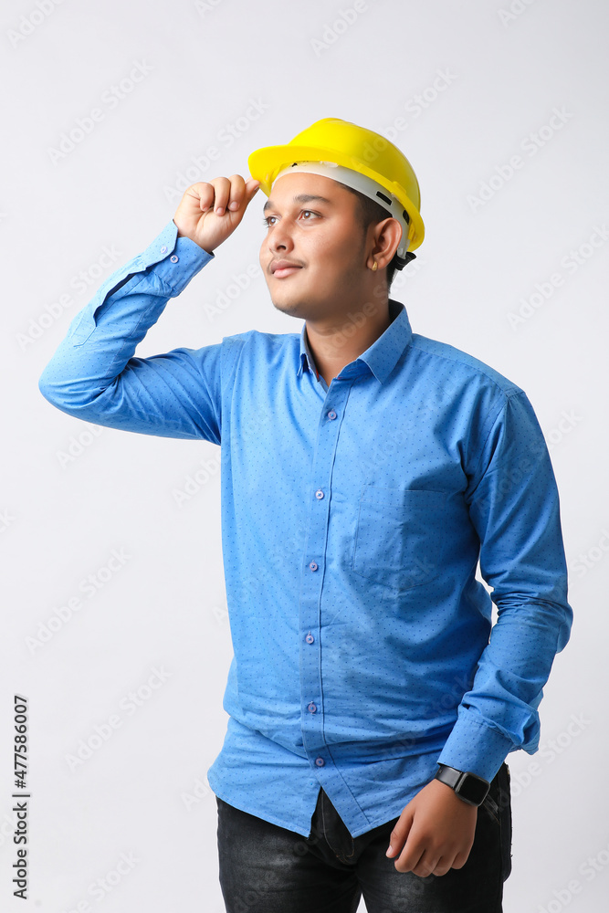Young Indian engineer wearing yellow color hard hat and giving successful gesture. Young Indian engineer wearing yellow color hard hat and giving successful gesture.