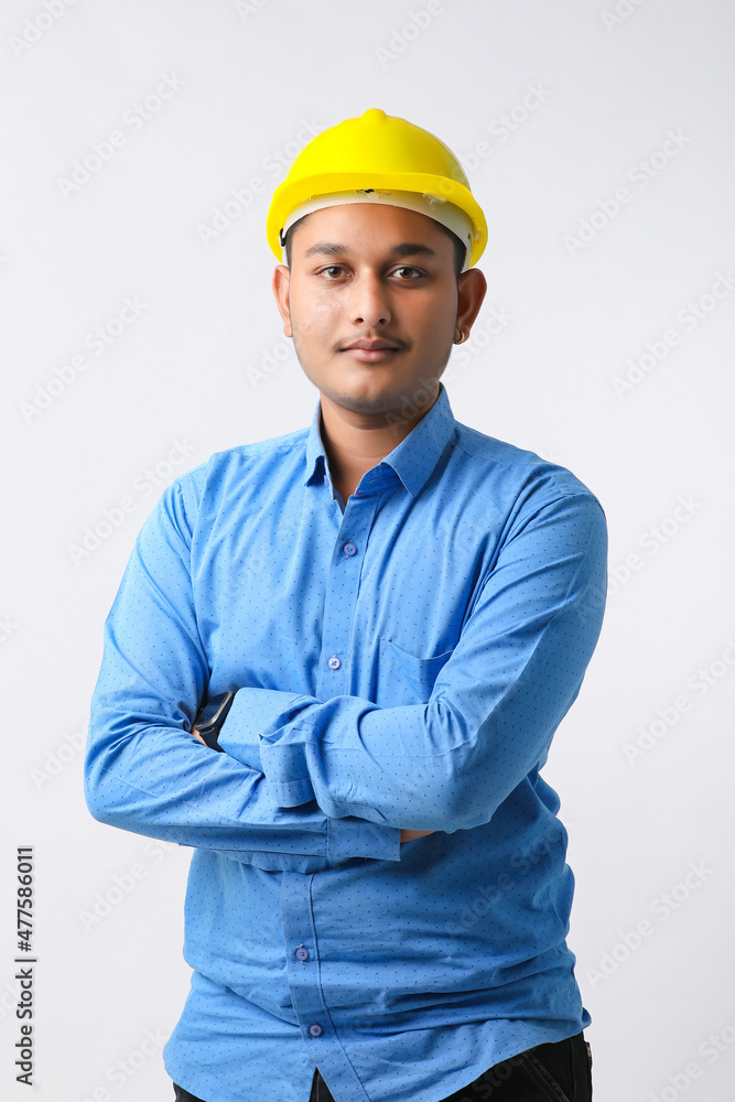 Young Indian engineer wearing yellow color hard hat and giving successful gesture.