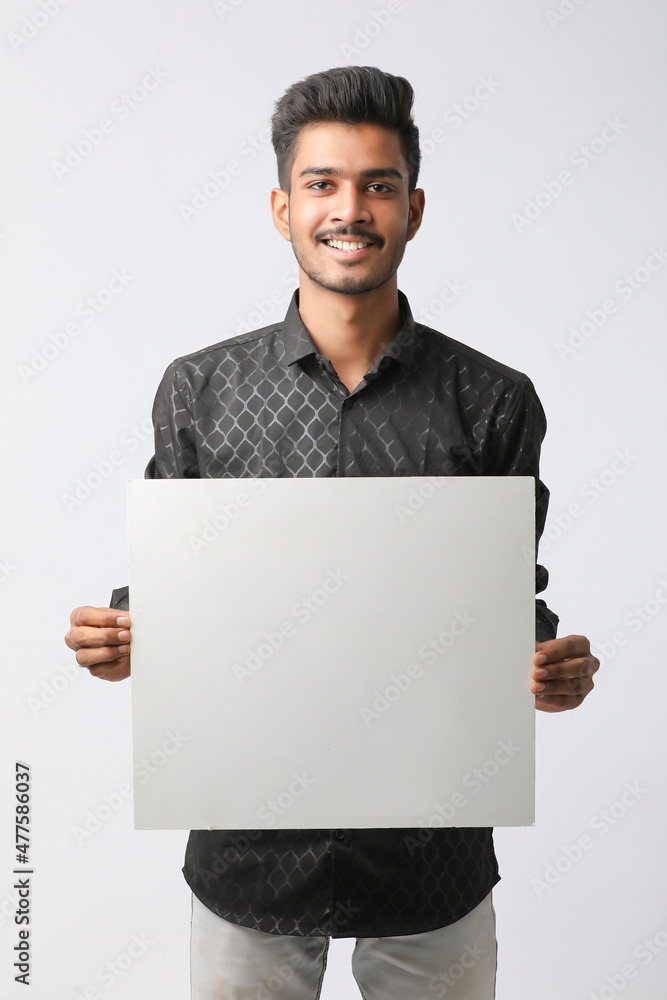 Young Indian college student showing blank signboard on white background. Young Indian college student showing blank signboard on white background.