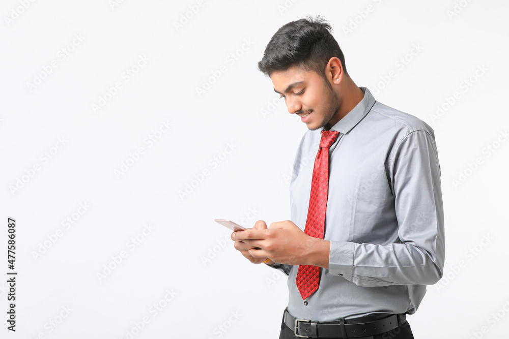 Young indian man using smartphone and giving expression on white background. Young indian man using smartphone and giving expression on white background.