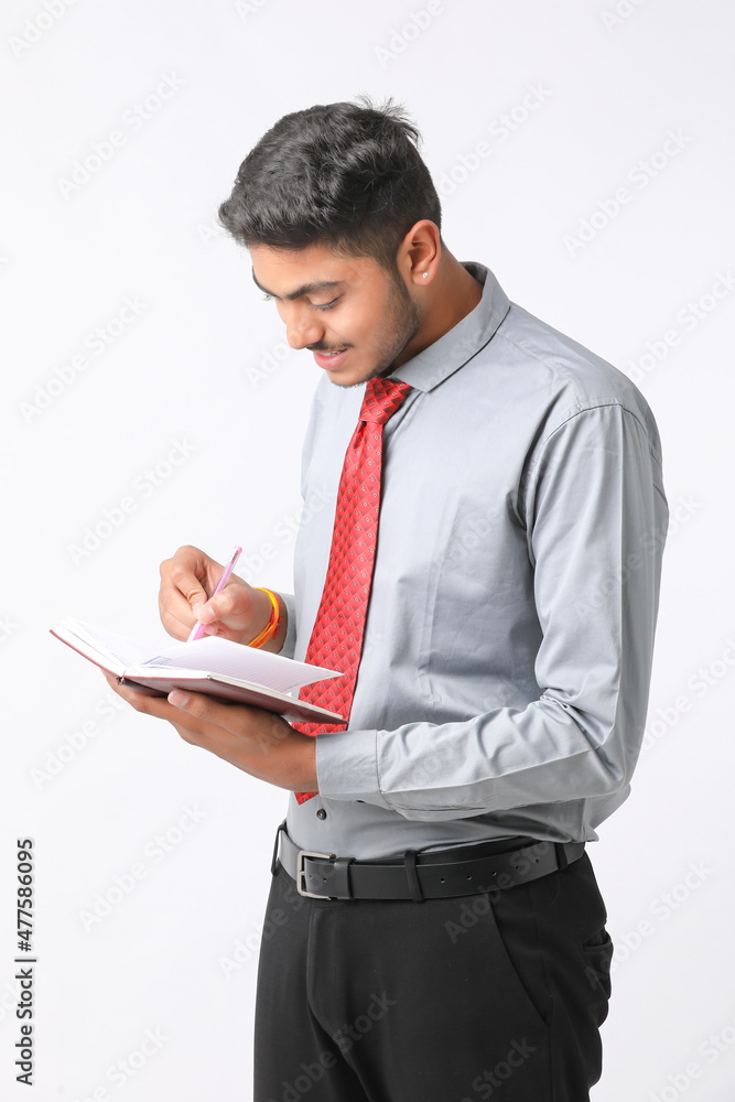 Young indian man holding diary in hand and thinking some idea. Young indian man holding diary in hand and thinking some idea.