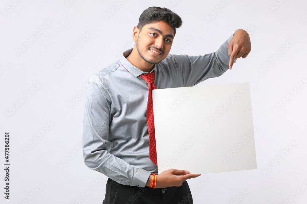 Young Indian business executive showing blank sign board over white background. Young Indian business executive showing blank sign board over white background.