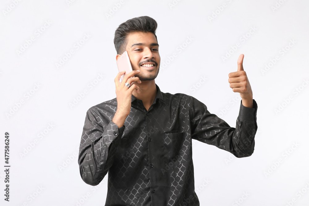 Young indian man talking on smartphone and giving expression on white background. Young indian man talking on smartphone and giving expression on white background.