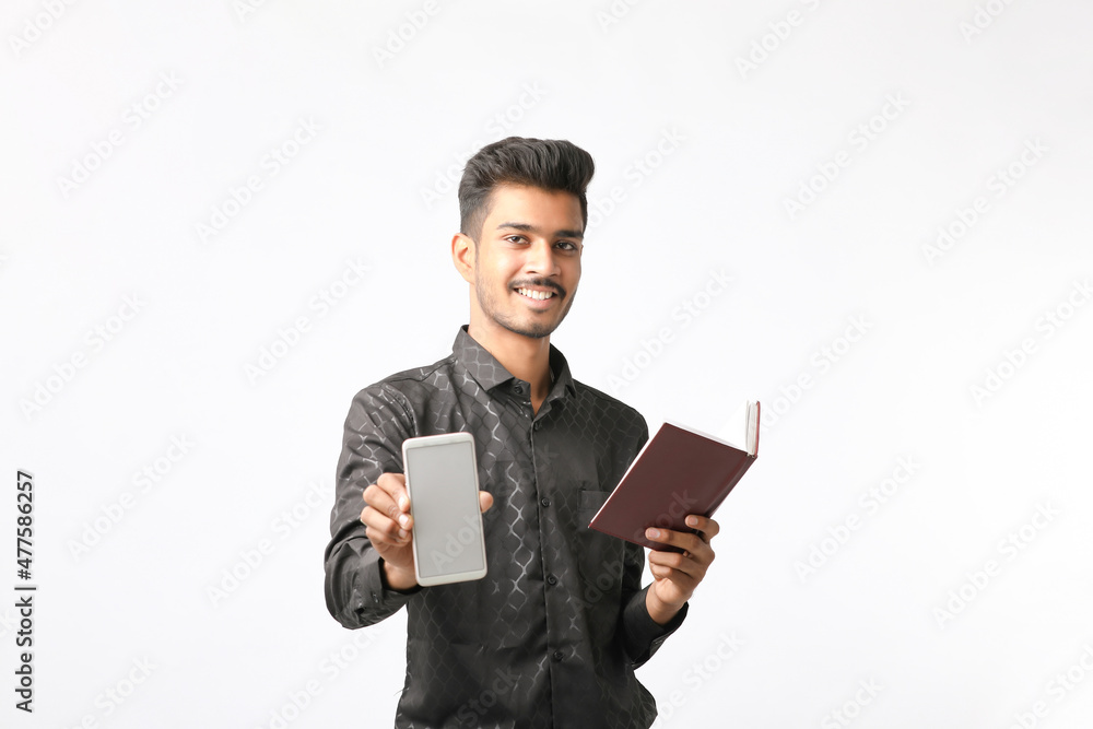 Young indian man showing smartphone screen on white background. Young indian man showing smartphone screen on white background.