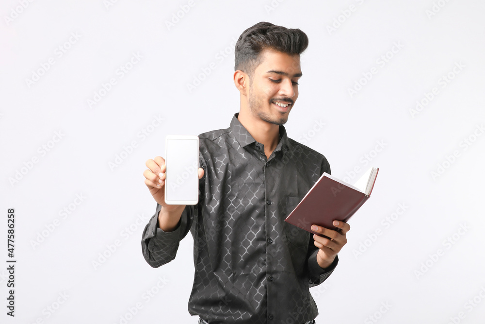 Young indian man showing smartphone screen on white background. Young indian man showing smartphone screen on white background.