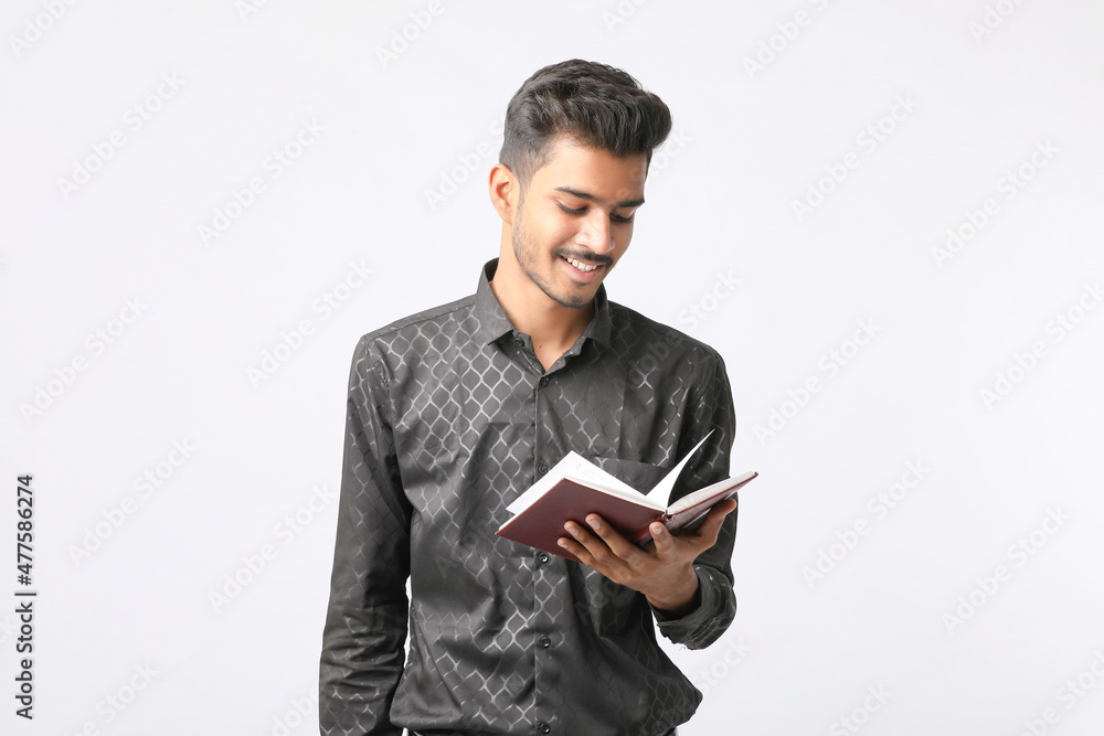 Young Indian college student holding diary in hand on white background. Young Indian college student holding diary in hand on white background.