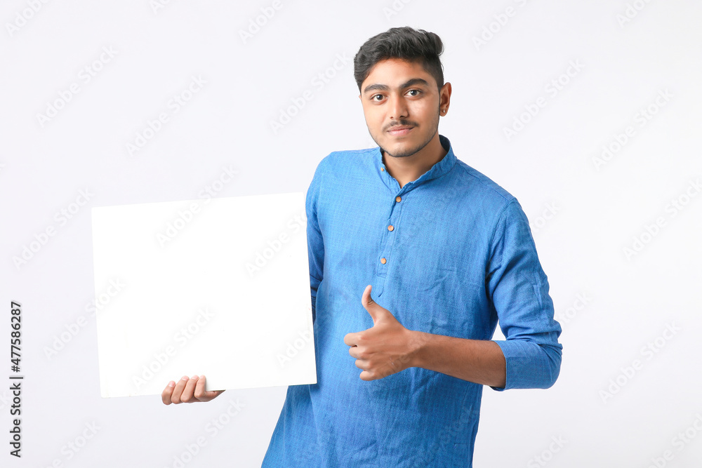 Indian man holding white board, promoting offers on festival season while wearing traditional cloths, standing over white background.