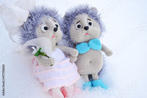 a pair of toy hedgehogs in wedding clothes on a white background,a holiday concept photo