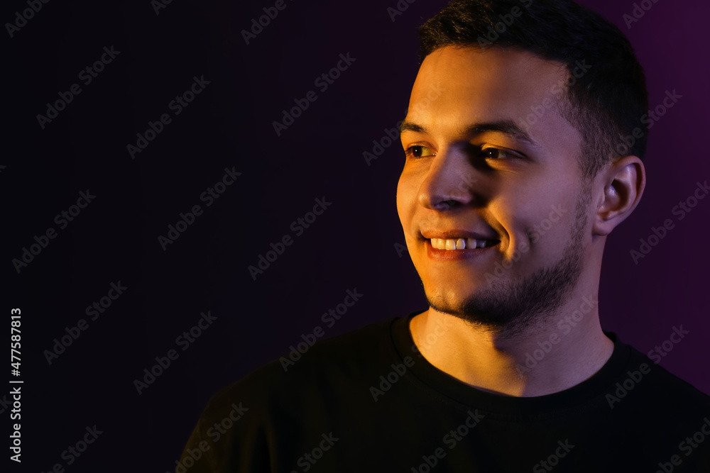Obraz premium Toned portrait of handsome young man on black background