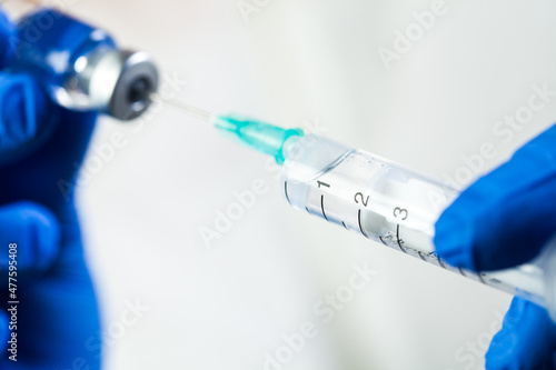 Extreme closeup of syringe with needle in glass ampoule vial photo