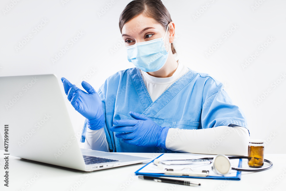 Young female doctor advising patient via online computer call during Coronavirus pandemic