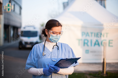 Young caucasian female doctor in front of emergency medical services clinic