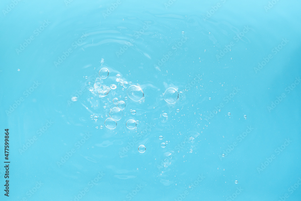 Water drops falling on the blue water.