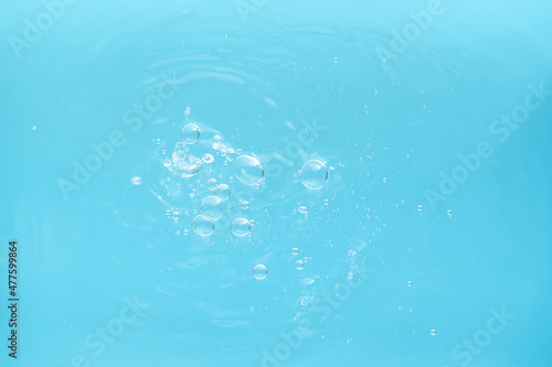 Water drops falling on the blue water.