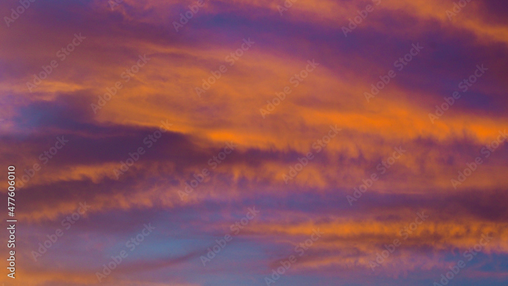 Somptueuses traînées de lumière rouges et oranges, sous des nuages de type Cirrus et Cirrostratus