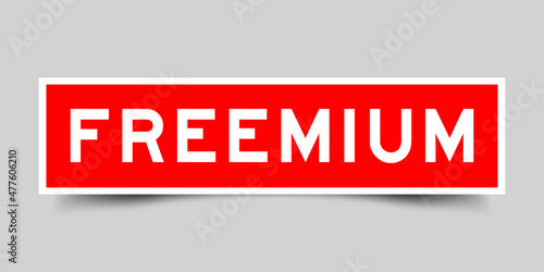 Sticker label with word freemium in red color on gray background