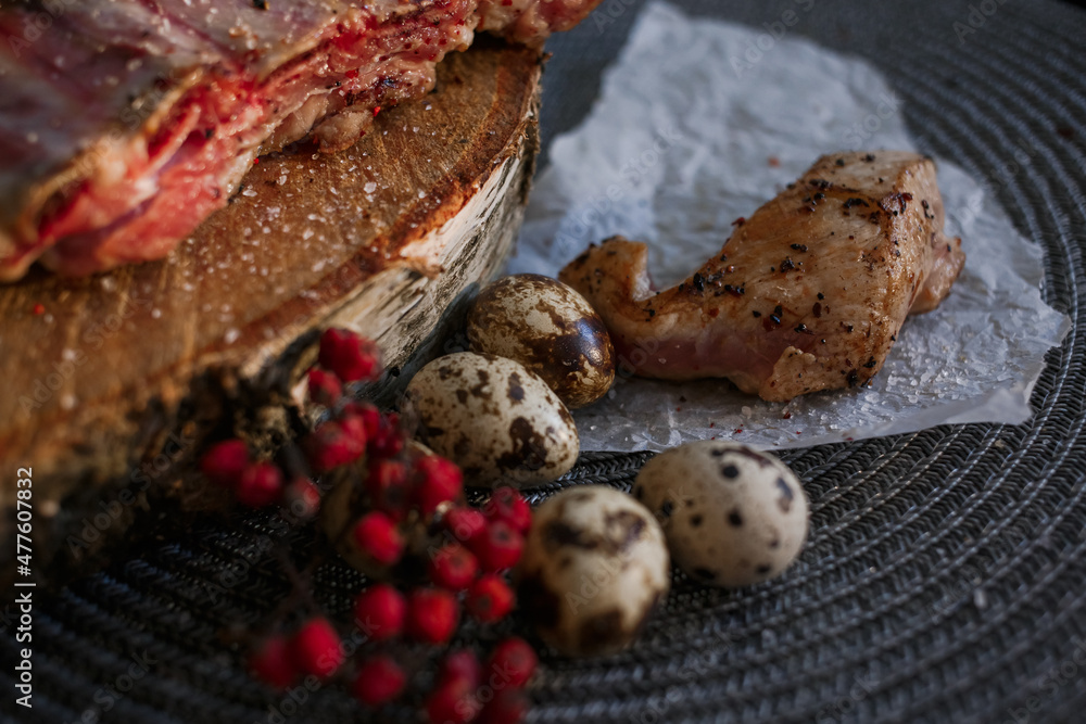 A delicious piece of meat cooked on the grill lies on a wooden board with berries A delicious piece of meat cooked on the grill lies on a wooden board with berries