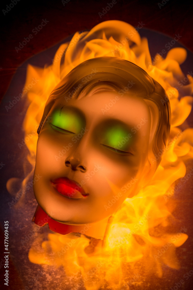 This abstract photograph of a flaming mannequin head was photographed using a technique called painting with light. Green eyes and red lips were painted using a fibre optic cable, Johannesburg, South 