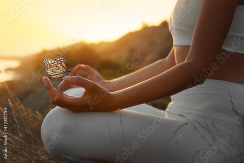 Fototapeta Woman meditating outdoors at sunset, closeup view