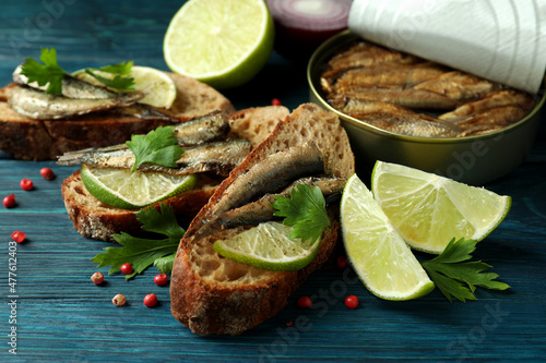 Concept of tasty snack with sandwiches with sprats on wooden background