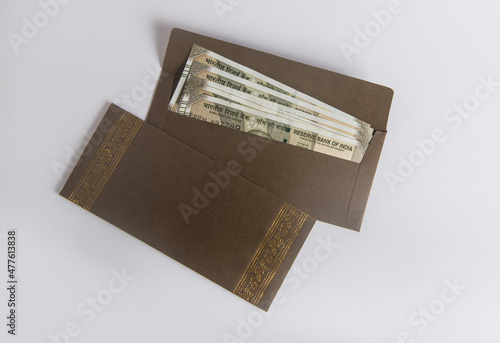 Indian currency notes placed in a decorative paper envelope. Idea for 'Festive cash gift, 'Cash rewards' or 'Cash donation for charity'