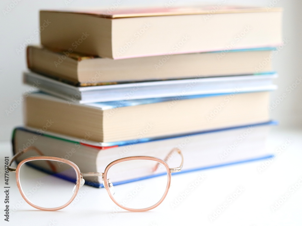 Stack of books and glasses isolated on table, on white background. Stack of books and glasses isolated on table, on white background.