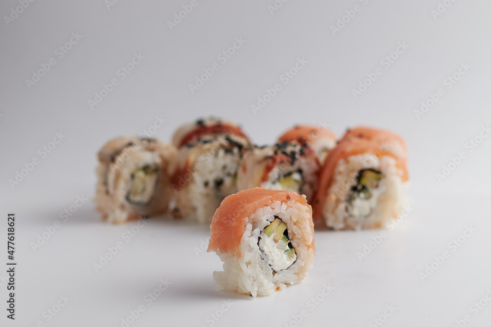 One roll in focus, a portion of rolls out of focus, Asian food, sushi and fish dish One roll in focus, a portion of rolls out of focus, Asian food, sushi and fish dish