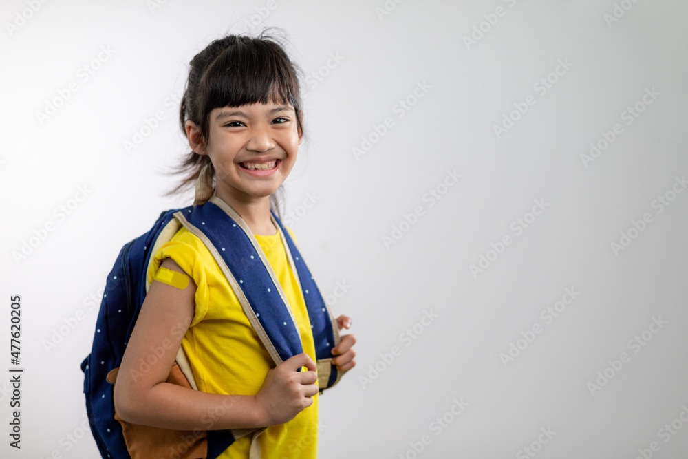 Asian young girl showing her arm with yellow bandage after got vaccinated or inoculation, child immunization, covid delta vaccine concept Asian young girl showing her arm with yellow bandage after got vaccinated or inoculation, child immunization, covid delta vaccine concept