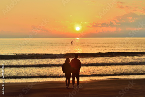 湘南海岸で夕日を望むカップル