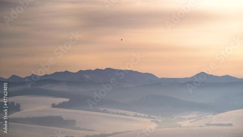 Single air balloon over incredible silhouetted winter mountain landscape at sunset photo