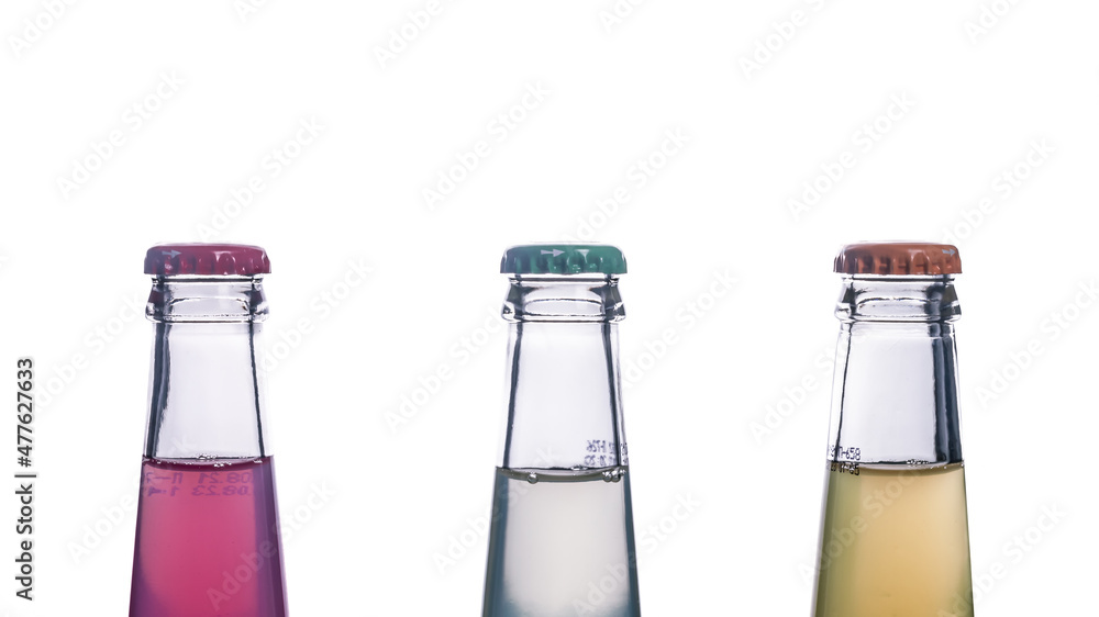 Three glass bottles with multicolored beer, drink, soda on a white background