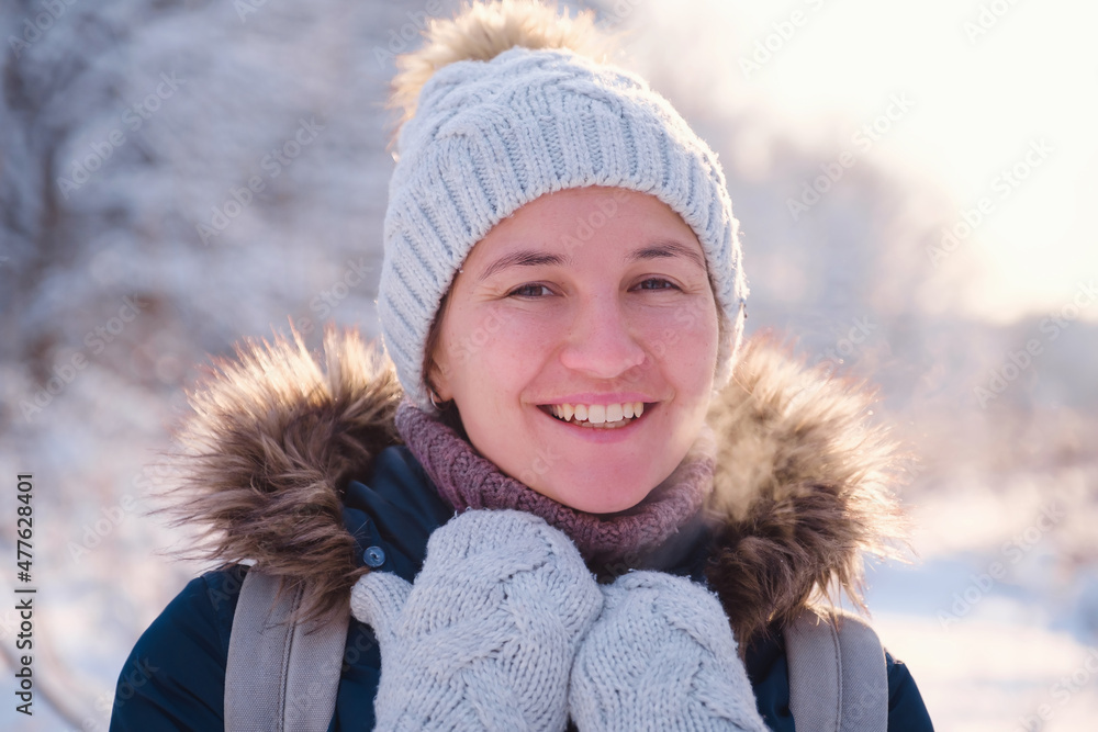 Happy Asian woman walking in winter snow forest. Cold weather hat and warm coat. idea and concept of healthy active lifestyle and good mood in any weather Happy Asian woman walking in winter snow forest. Cold weather hat and warm coat. idea and concept of healthy active lifestyle and good mood in any weather