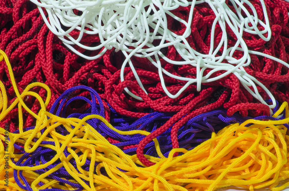 close up of colorful rope. textured strap stock. yellow, red, blue and white rope mounds. Yarn strands with coarse fibers are stacked irregularly