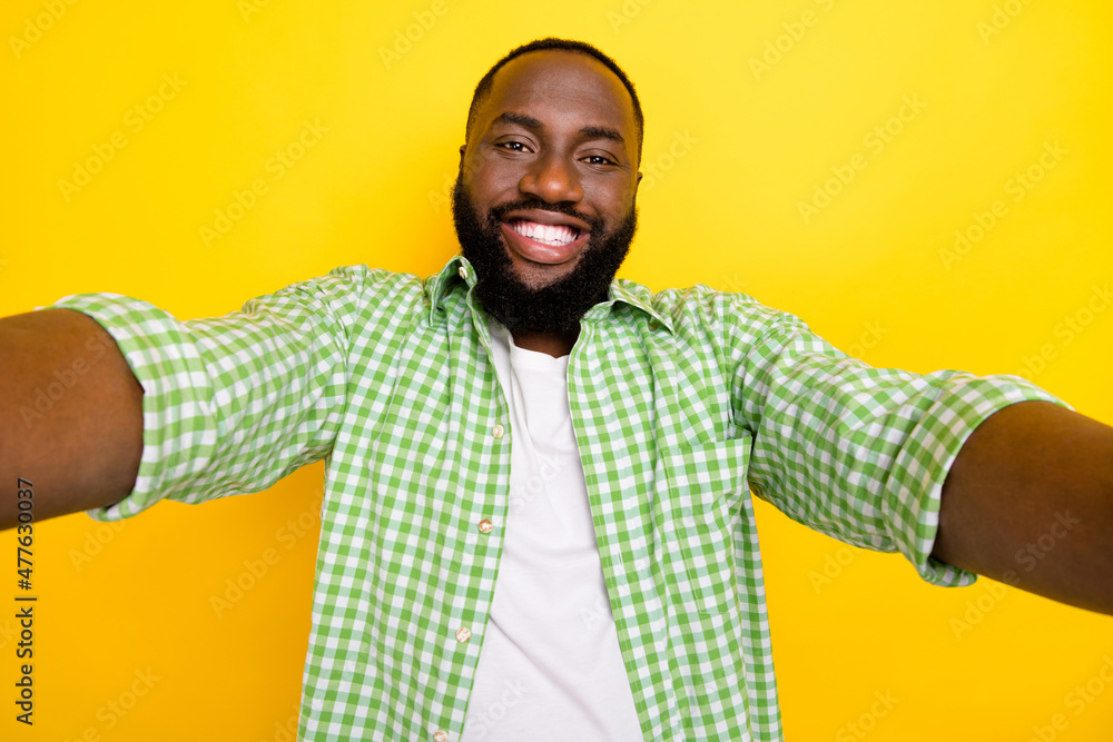 Portrait of satisfied young man take selfie toothy beaming smile isolated on yellow color background Portrait of satisfied young man take selfie toothy beaming smile isolated on yellow color background