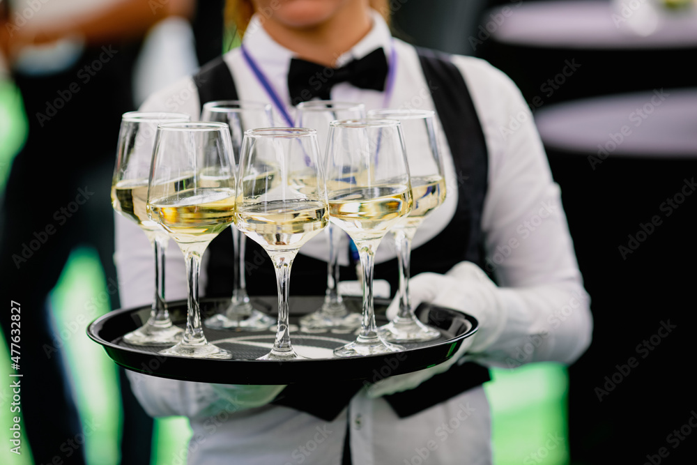 Shallow depth of field (selective focus) details with a waiter walking around and offering glasses of wine to the guests of an event. Shallow depth of field (selective focus) details with a waiter walking around and offering glasses of wine to the guests of an event.