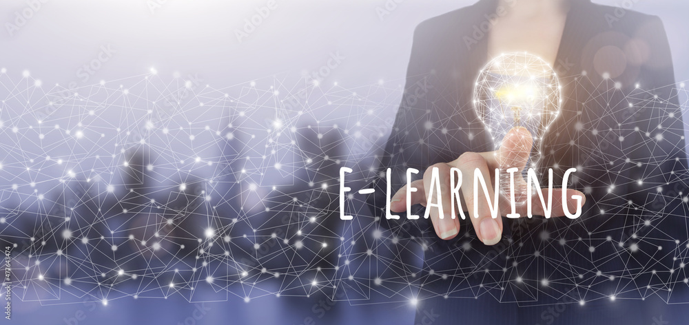 E-learning Internet Education Webinar Online Courses. Hand touch digital screen hologram light bulb, e-learning sign on city light blurred background.